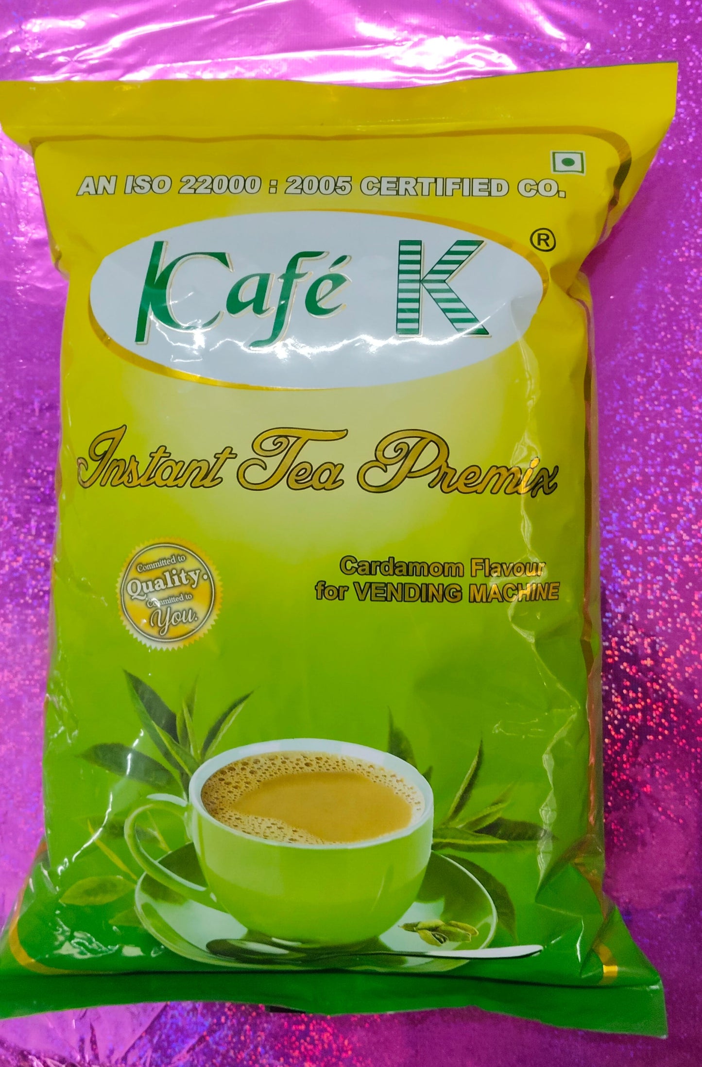 Cafek tea premix cardamom instant tea premix in green and yellow pack with cup of tea on front