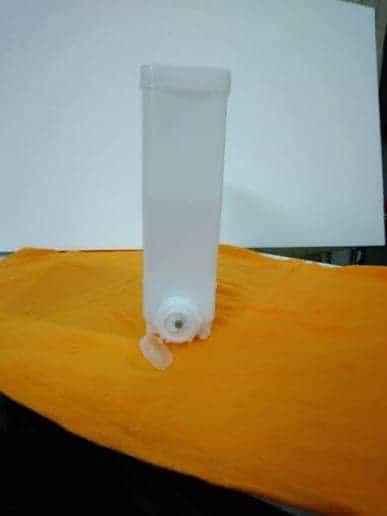 White plastic component for Godrej coffee machine replacement part by COFFEE WALLA on orange background