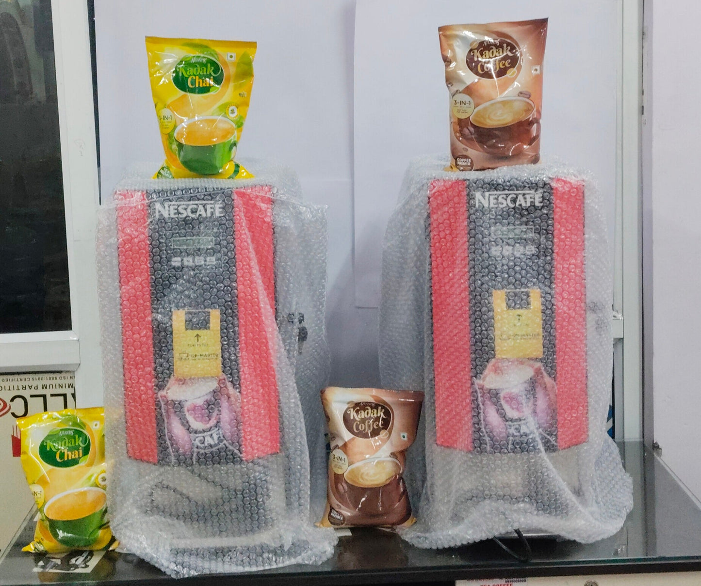 Amazon tea coffee machine Noida showing two Nescafe machines wrapped in bubble wrap with tea and coffee packets