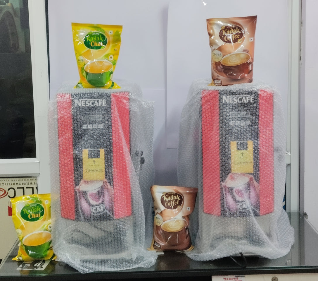 Two Nescafe coffee machines wrapped in bubble wrap with tea and coffee packets displayed Amazon tea coffee machine Noida
